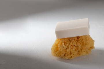 Set eco friendly bath devices. A soap bar with natural bath sponge a concrete background.