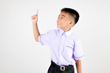 Portrait smile Asian little boy primary posing point finger to side away studio isolated white background, happy cute man kid wear school uniform plaid innocence and curiosity, back to school concept