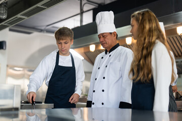 Group of student boy and girl studying cooking to be junior chef in class at school kitchen. Senior...