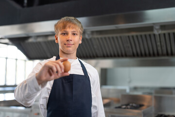 Student boy studying cooking food in class at school kitchen.