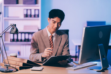 Businessman working hard overtime at night at the office. He felt tired and stressed from work.