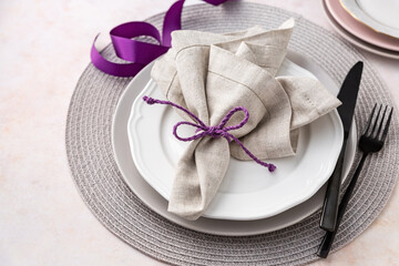 Purple and grey napkin on plates, elegant place setting table arrangement on table angle view