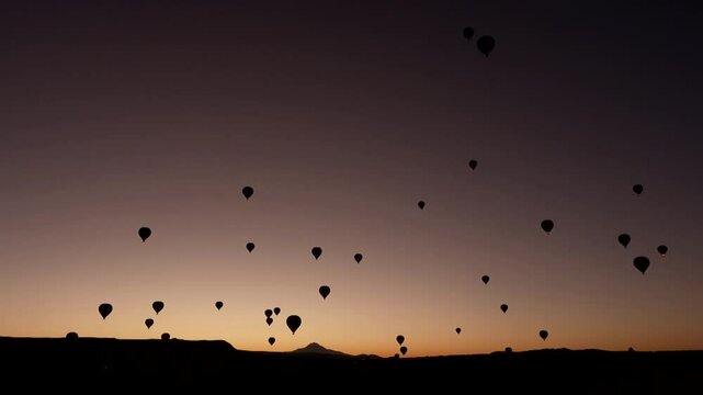 group of hot air balloons at sunset shot in slowmotion
