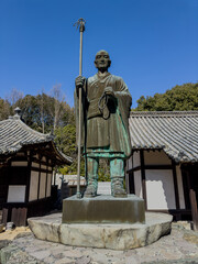 Fototapeta premium Statue of Kukai at Japanese Temple Under Blue Sky, Taisanji Temple, Ehime, Japan, 52 of 88