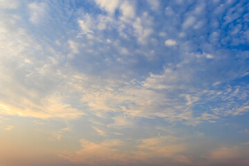 The morning sky with soft scattered clouds. The sky has a gradient from warm pale yellow below to cool light blue above. Cloud formations are soft and thin.