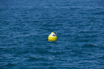 Eine gelbe Boje (nautic sea buoy) im blauen Meer
