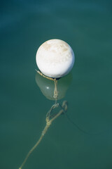 Eine runde weiße Boje (nautic sea buoy) mit Spiegelung - Hochformat