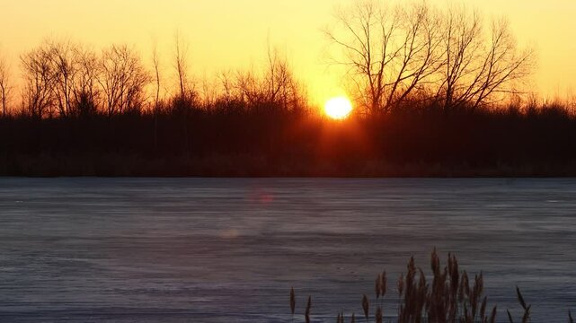 North-eastern European river after frosty winter. Porous fibrous ice began to melt, river is swollen, state of ice week before ice break (ice-boom). Aurora, sunrise colors on a spring moning