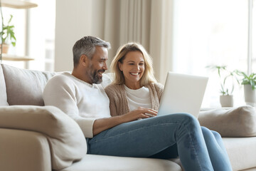 Obraz premium Joyful Middle-Aged Couple Relaxing at Home