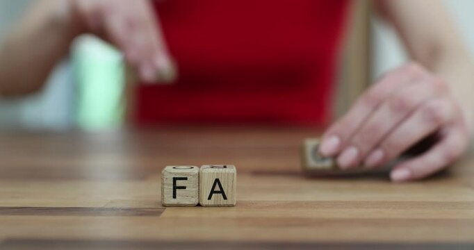 Woman hand transforms word Fake into Fact changing wooden cubes at table. Female warns about truth and misinformation in communication