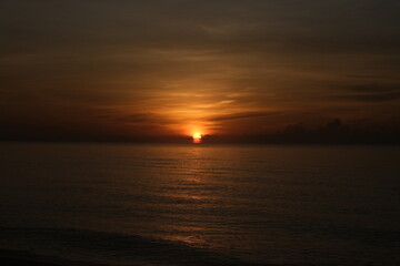 The sun rises at the sea in the morning.