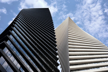 Two beautiful modern office skyscrapers against the sky. Building exterior, business, construction...