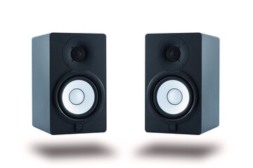 Pair of professional high quality monitor speakers for sound recording, mixing, and mastering in studio in black wooden casing isolated on white background.