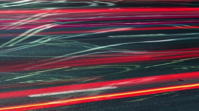 Long exposure time-lapse rush hour drive in big city at night, bright colorful light trails from vehicles, lot of driving cars speedy traffic lights blurred fast motion, abstract timelapse city life