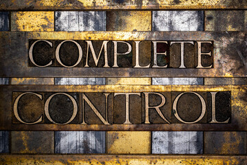 Complete Control text in real authentic typeset letters on vintage textured silver grunge copper and gold background