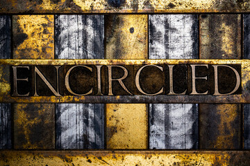 Encircled text in real authentic typeset letters on vintage textured silver grunge copper and gold background