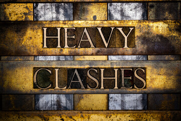 Heavy Clashes text in real authentic typeset letters on vintage textured silver grunge copper and gold background