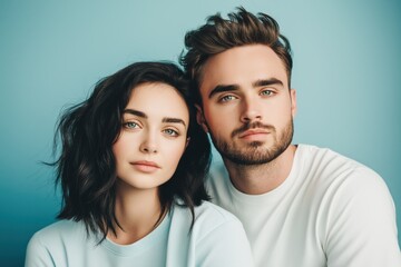 Obraz premium A studio close-up portrait of a young white couple wearing casual t-shirts, with a colourful background.