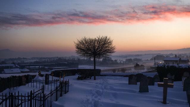 Snowy cemetery and railroad in Swiss landscape