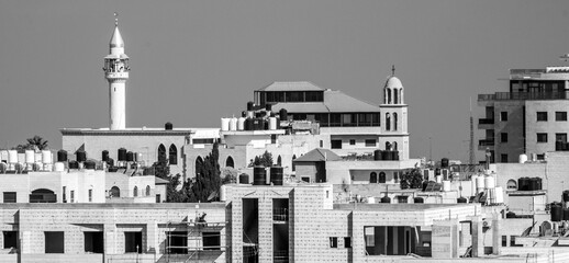 Black and white panorama of the skyline of Ramallah, Palestine with a minaret and Christian church...