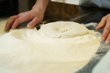 Making a pizza, close up of hands kneading the pizza dough