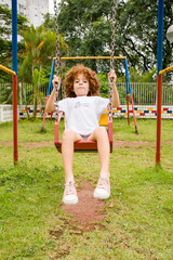 Child girl playing in the playground on the building's playground on a sunny green day