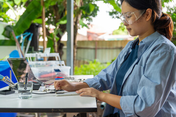 Asian woman installing analog dissolved oxygen sensor to microcontroller. Agriculture and...