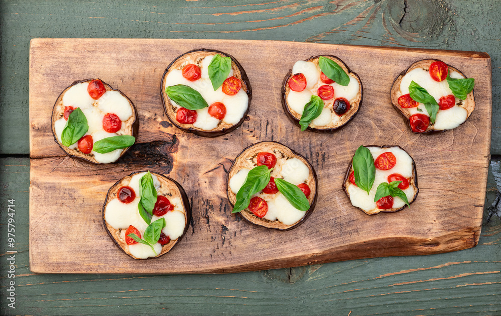 Poster italian mini pizza . aubergine (eggplant ) with mozzarella cheese and basil . on rustic background