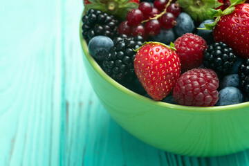 Mix of ripe colorful berries in bowl photography . Blueberry , strawberry , raspberry , blackberry and red currant . Top view