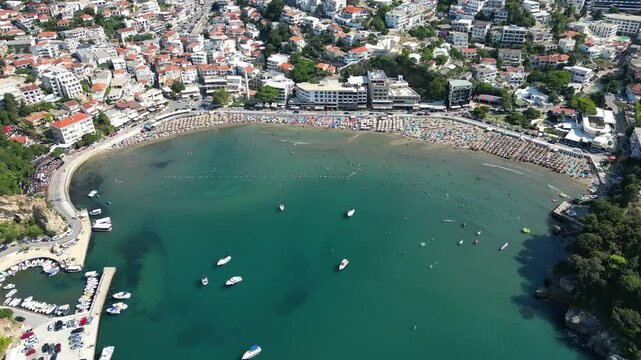 Aerial view of the resort town of Ulcinj in Montenegro and its central beach filled with people on a sunny summer day