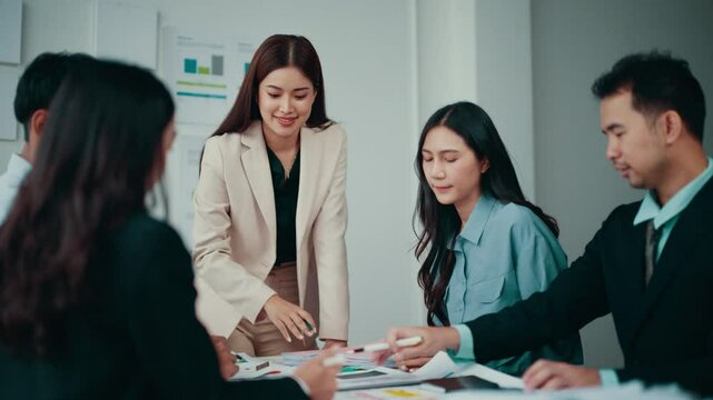 Team of asian professionals gathered around a table, engaging in a productive brainstorming session. They collaborate effectively, leveraging their expertise to achieve shared objectives