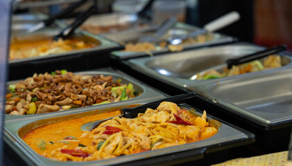 Asian dishes with nuts, vegetables, and meat offered at a buffet at a market stall in the city.