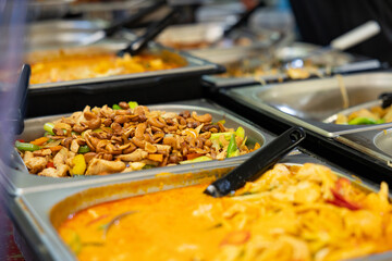 Asian dishes with nuts, vegetables, and meat offered at a buffet at a market stall in the city.