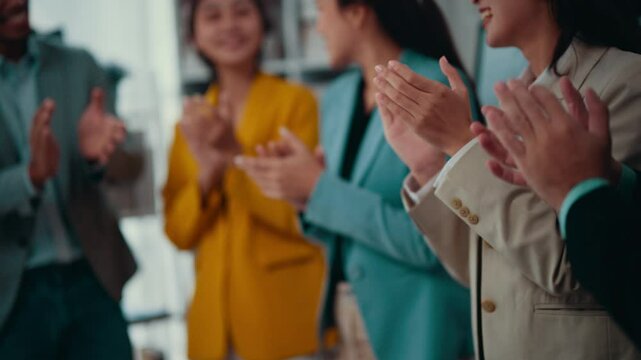 Team of diverse business professionals is applauding enthusiastically, celebrating a significant achievement or milestone