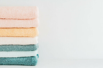 A pile of colorful towels with a white background.