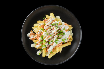 Savory fries topped with seasoned meat and creamy sauce, presented on a stylish black plate in a modern dining setting