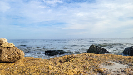 Seascape background with rocks in summer daytime. View of the Black Sea behind a large brown rock
