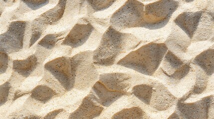 Detailed close-up of sand patterns created by wind and water erosion on a beach during a sunny day