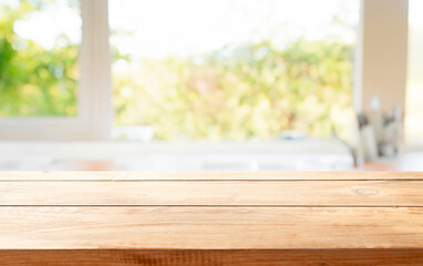 wooden table close up, against wall with warm sunset light from window, table for advertising display your products.
