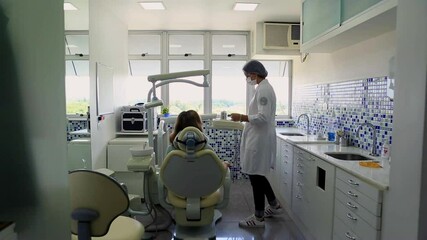 Dentist showing a patient around a dental clinic, explaining equipment and providing introduction to the dental procedure in a clean, modern, and professional healthcare environment