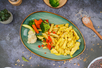 Veggie Pasta in a dish on a gray background, top view.