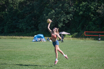 Female volleyball player serving the ball. Grass doubles tournament.