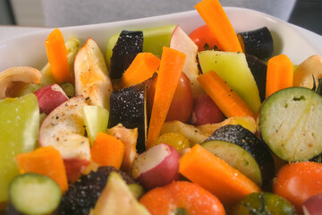 Woman adding salt pepper to fresh vegetables fruit herb on baking sheet to bake. Preparing dish on kitchen at home. Ingredient recipe cuisine culinary. Homemade healthy meal.