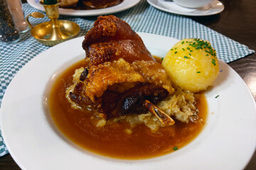 Traditional Bavarian Pork Knuckle with Sauerkraut and Potato Dumpling in Rich Gravy - Authentic German Cuisine