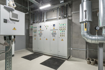 The control room displays advanced electrical panels and monitoring systems, with safety indicators...