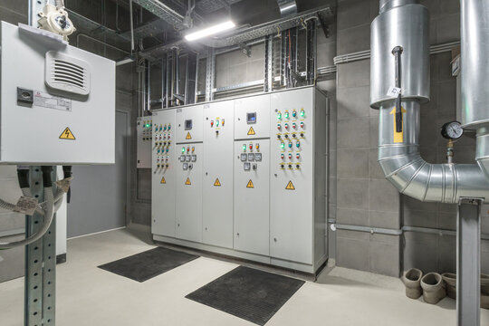 The control room displays advanced electrical panels and monitoring systems, with safety indicators clearly visible in a well-organized commercial setting.