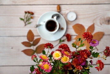 Autumn composition. Cup of coffee, notepad, fresh flowers on white background. Autumn, fall concept. Flat lay, top view, copy space