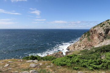Vom Wanderweg Skaneleden aus ist der Ausblick auf die Klippen der Halbinsel Kullen und den Öresund möglich. Unten branden Wellen gegen die Felsen. Der Weg führt in Schweden von Mölle nach Kullens fyr.