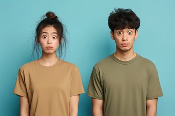 A studio close-up portrait of a young Asian couple wearing casual t-shirts, with a colourful background.