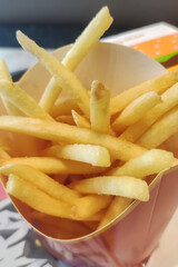 Box of fries in a restaurant setting, showing golden fries in their packaging.